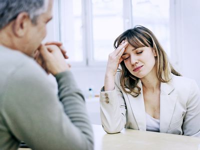 Woman with headache, talking with Doctor