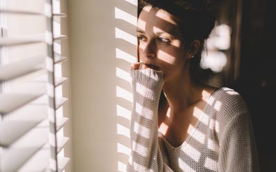 Sad woman looking through the window