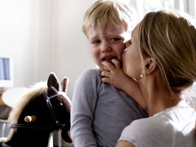 toddler crying in mother's arms