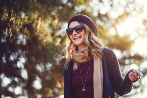 Woman walking outdoors while smiling.