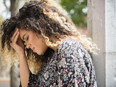 Mixed Race woman rubbing forehead