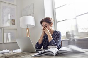 tired woman with her eyes closed at her desk