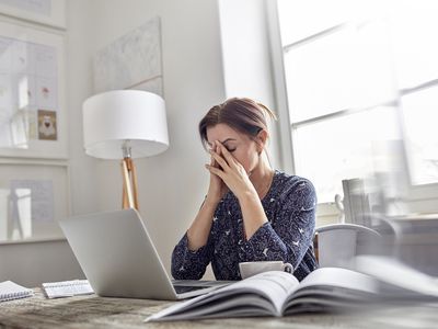 tired woman with her eyes closed at her desk