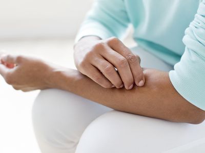 Woman picking skin on arm