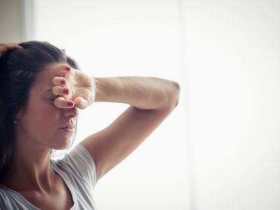 Woman not feeling well with hand on head