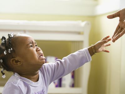 Upset baby reaching for parent