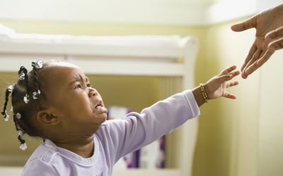 Upset baby reaching for parent