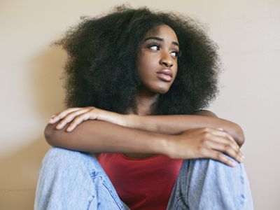 Mixed race woman sitting with arms crossed 