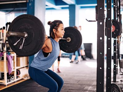 Woman cross training and weight lifting at the gym