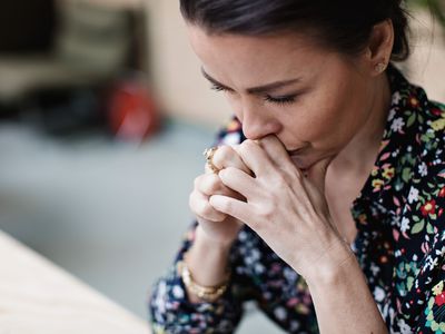 Close-up of tired thoughtful businesswoman with arms crossed at office