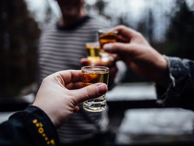 Close-Up Of Hands Holding Alcoholic Drinks