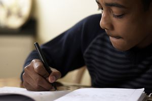 Close-up of boy (12-13) doing homework at desk