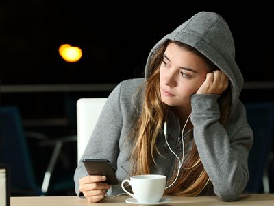 Sad teenager listening to music in a bar