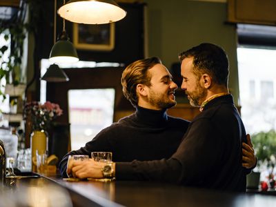 Two gay men gaze passionately into each other's eyes, about to exchange a kiss 