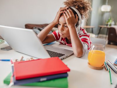 Young girl having trouble paying attention while attending class online