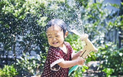 Little girl spraying water hose