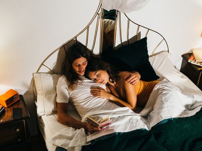 Young couple reading at bed before sleeping.