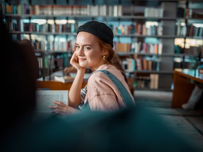 Close up of a group of young students in a library reading their books