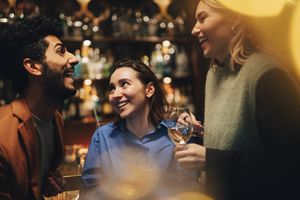 3 friends talking at a bar