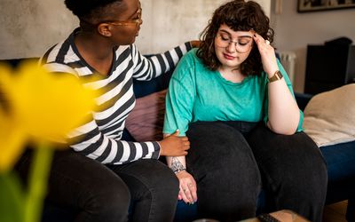 Two women are sitting in the living room talking