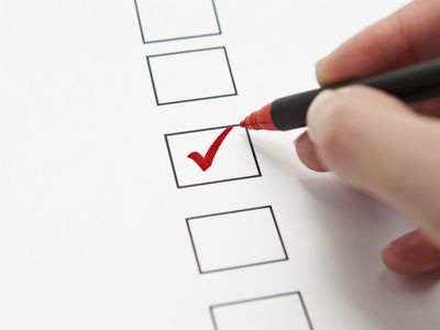 Person checking a checkbox with red pen