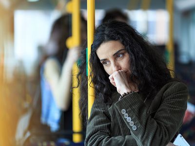 Pensive young woman traveling and holding smart phone