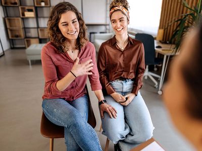 Counselor advising young lesbian couple at their home