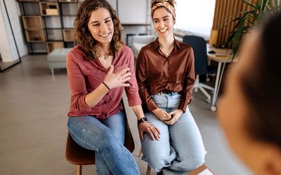 Counselor advising young lesbian couple at their home