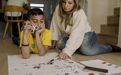 Mother teaching son while sitting at home