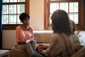 Therapist asking questions to a parent and child and taking notes