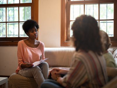 Therapist asking questions to a parent and child and taking notes