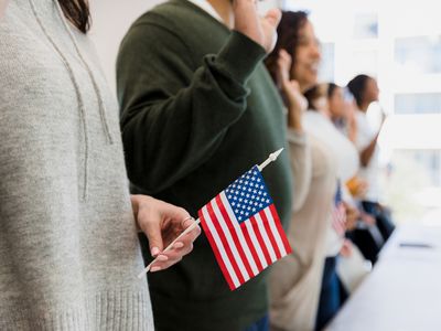 people saying the pledge of allegiance, one woman holding American flag