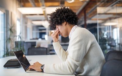 Man working late at his computer feeling stressed