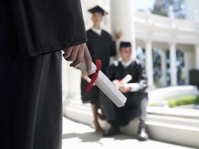 student standing with their psychology degree in their hand