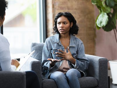 The young adult woman gestures while describing an event that happened in her past and the reason she reacted a particular way.