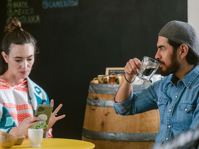 Modern marriage enjoying together having a coffee cup and using smartphone at cosy cafeteria