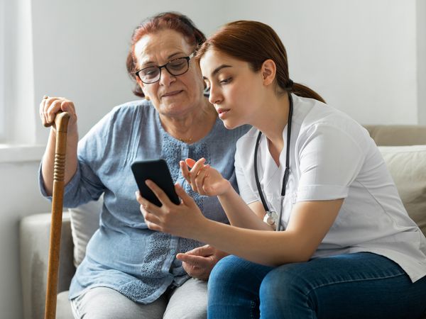 Senior woman with nurse at home