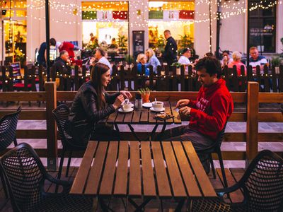 white man and white woman having coffee on a patio