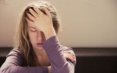 distressed woman with hand on her head