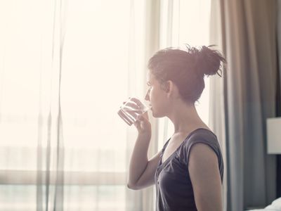 Young woman drinking water in the bedroom